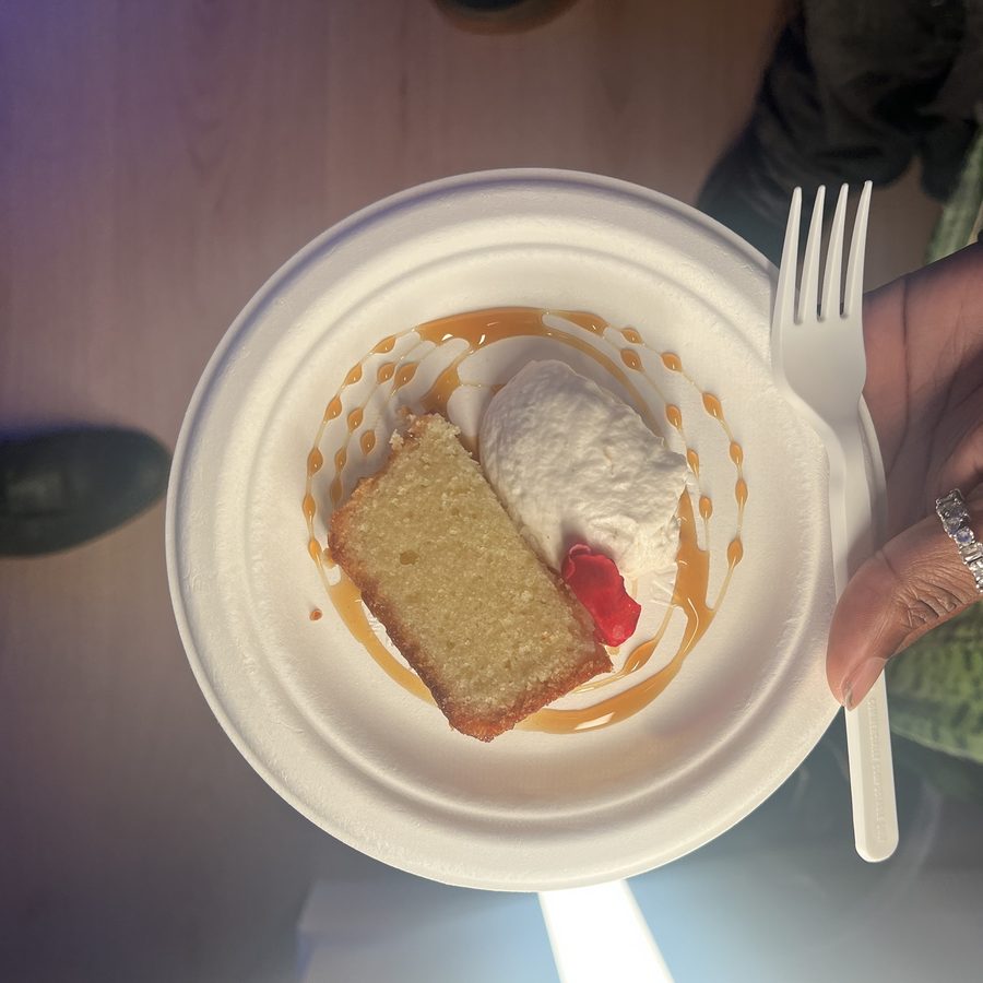 Slice of pound cake with whipped cream, caramel and a rose petal